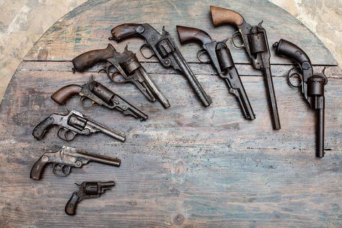 series of antique pistols lined up